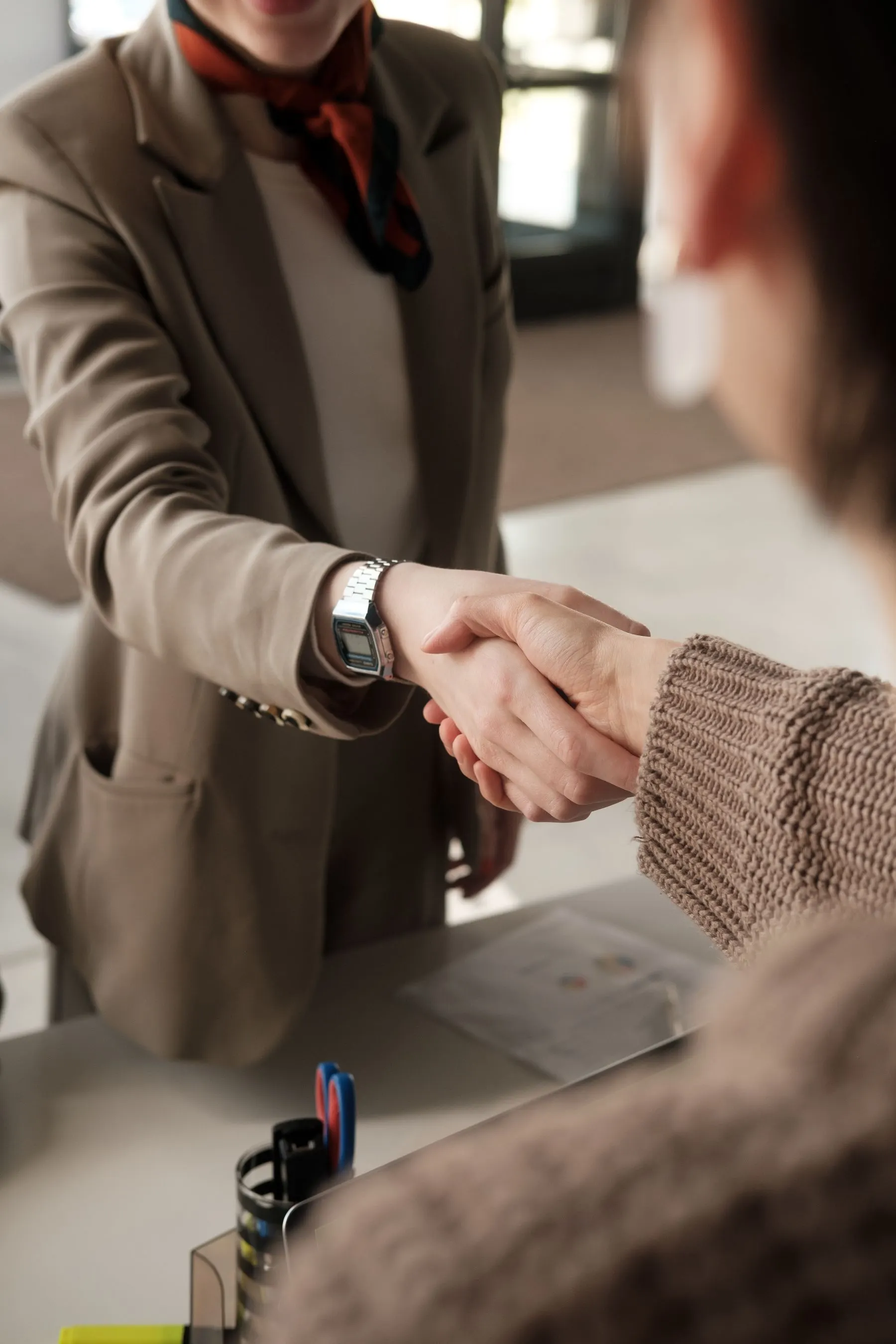 Two professionals shaking hands across a table