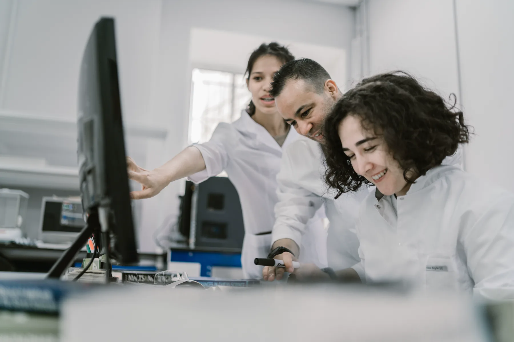 Research team collaborating around a computer in a modern laboratory